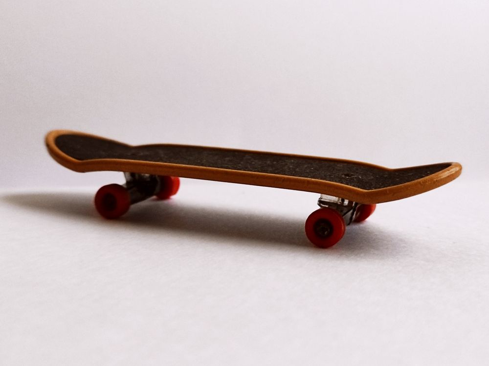 Stock reference of an assembled fingerboard with black grip and red wheels, not a Custom Fingerboard product